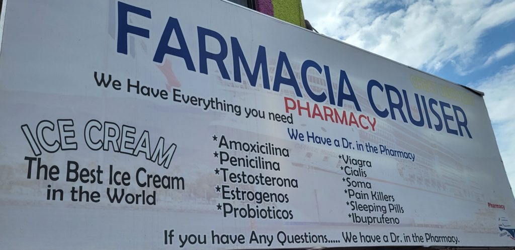 Store sign for Farmacia Cruiser, advertising all sorts of drugs you can buy there, plus ice cream.