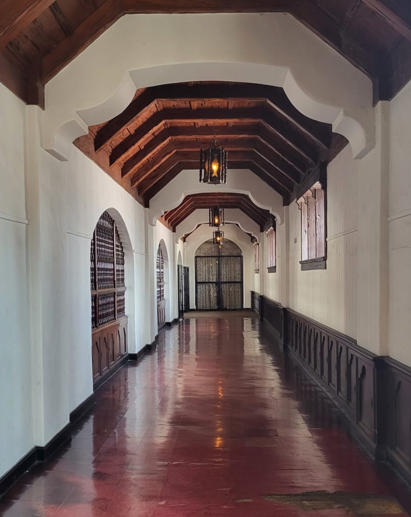 Beautiful hallway with shiny floors and wooden beams on the ceiling.