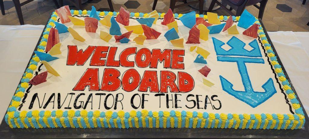 A giant sheet cake from the buffet that says Welcome Aboard, Navigator of the Seas.